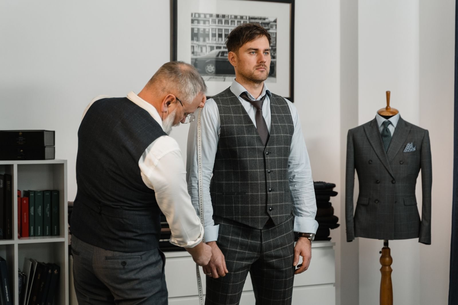 Tailor taking a client's measurements for a suit